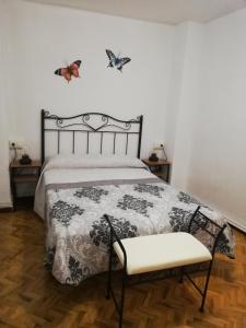 1 dormitorio con 1 cama con mariposas en la pared en Casa Rural La Callejuela en Ayllón