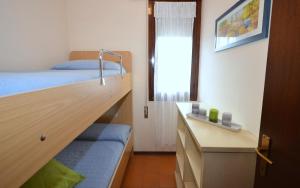 ビビオーネにあるAppartamenti Laguna & S.Elena Sudのベッドルーム1室(ベッド1台、デスク、窓付)