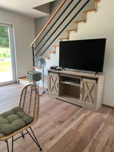 a living room with a flat screen tv and a chair at Boya Home in Wilkasy