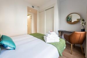 マドリードにあるApartamento con jardin privadoのベッドルーム1室(ベッド1台、椅子、デスク付)