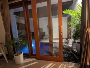 an open door with potted plants in a room at Bright Peaceful Villa in Kerobokan