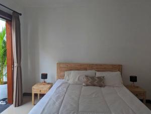 a bedroom with a large bed with two night stands at Bright Peaceful Villa in Kerobokan
