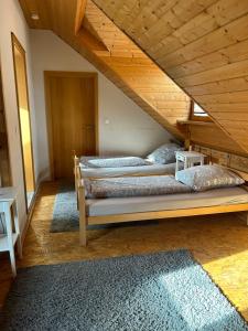 three beds in a room with wooden ceilings at Pension Zum Paradies in Harthausen