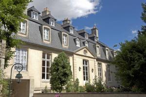 un gran edificio blanco con techo gris en Hôtel d'Argouges en Bayeux