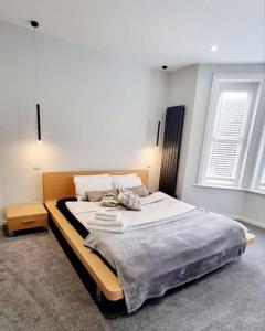 a large bed in a room with two windows at Stylish Flat in Bournemouth Town Centre in Bournemouth