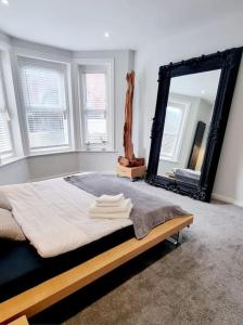 a bedroom with a bed and a large mirror at Stylish Flat in Bournemouth Town Centre in Bournemouth
