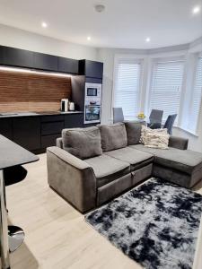 a living room with a couch and a kitchen at Stylish Flat in Bournemouth Town Centre in Bournemouth