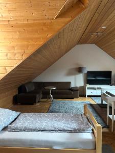 a living room with a bed and a wooden ceiling at Pension Zum Paradies in Harthausen