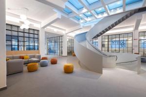 a lobby with a staircase and couches in a building at S4 Stays in Florence
