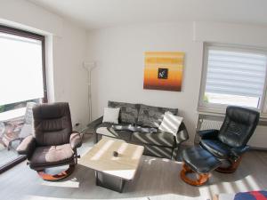 a living room with a couch and chairs and a table at Ferienwohnung Emilia, FeWo Vermittlung Nordsee in Dangast
