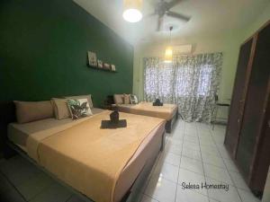 zwei Betten in einem Zimmer mit grüner Wand in der Unterkunft THE GREEN @SELESA HILLHOMES BUKIT TINGGI BENTONG in Bentong + 31 Fotos