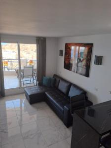 un soggiorno con divano nero e tavolo di Vista taurito Ely a Taurito