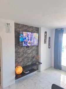 a living room with a tv on a wall at Vista taurito Ely in Taurito
