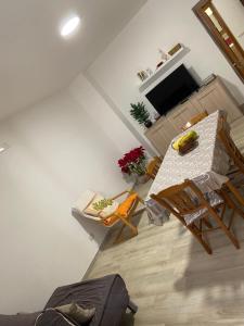 ein Wohnzimmer mit einem Tisch, Stühlen und einem TV in der Unterkunft Casa Felicia in Torre Annunziata
