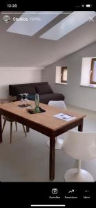 sala de estar con mesa de madera y sofá en Bretzenstudios, en Hall in Tirol