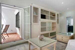 ein Wohnzimmer mit Glasschränken und einem Tisch in der Unterkunft El Velero in Chiclana de la Frontera