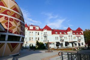 un grande edificio bianco con tetti rossi di Pysanka Hotel a Kolomyja