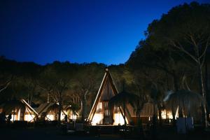 a house with a pointed roof at night at TAIGA Conil in Conil de la Frontera