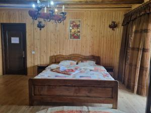 sypialnia z łóżkiem w pokoju z drewnianymi ścianami w obiekcie Cabana Magdalena w mieście Câmpulung