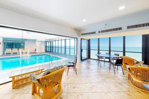 sala de estar con piscina, mesa y sillas en Golden Sands 809 en Ocean City