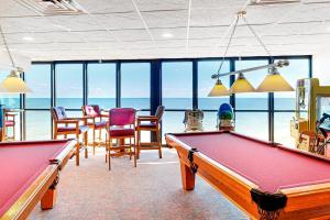 - un billard dans une pièce avec des chaises et des fenêtres dans l'établissement Golden Sands 809, à Ocean City