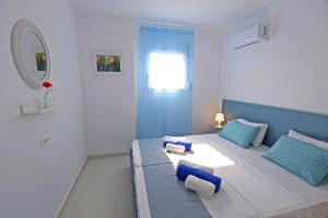- un salon doté d'un grand lit avec des oreillers bleus dans l'établissement Xenos Villa 5 with a Private pool near the sea, à Tigaki