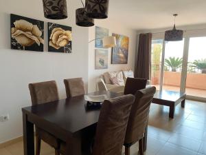 ein Wohnzimmer mit einem Esstisch und einem Laptop darauf in der Unterkunft Las Cycas Golf Resort in Torre-Pacheco