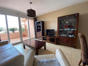 uma sala de estar com um sofá, uma mesa e uma televisão em Apto. Mar Menor Golf Resort em Torre-Pacheco