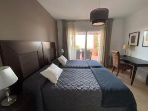 ein Schlafzimmer mit einem Bett mit einer blauen Decke und einem Schreibtisch in der Unterkunft Las Cycas Golf Resort in Torre-Pacheco + 15 Fotos