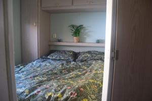 1 dormitorio con 1 cama con edredón de flores en Te Huur: leuke 4-persoons Stacaravan op top locatie! en Hoenderloo