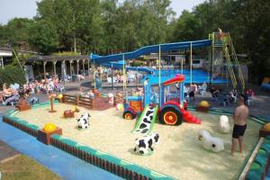 un parque infantil con un parque infantil con juguetes y gente en Te Huur: leuke 4-persoons Stacaravan op top locatie! en Hoenderloo