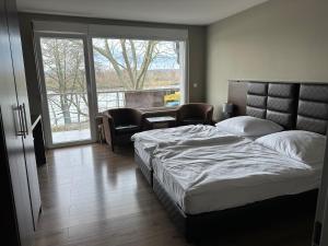 a bedroom with two beds and a large window at main Appartments in Kelsterbach