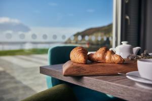 a table with croissants and a plate of croissants at Caban, Pendine Sands in Pendine