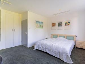 a white bedroom with a bed and a closet at Cosy apartment in Alkmaar with balcony in Alkmaar
