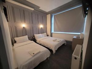 a hotel room with two beds and a window at The Woodland Hotel in Blackpool