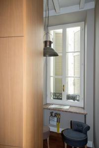 une cuisine avec une fenêtre et un tabouret bleu dans l'établissement Charme and relax in downtown Parma, à Parme 2 autres photos