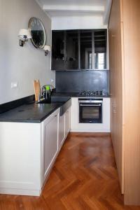 une cuisine avec des armoires blanches et un comptoir noir dans l'établissement Charme and relax in downtown Parma, à Parme