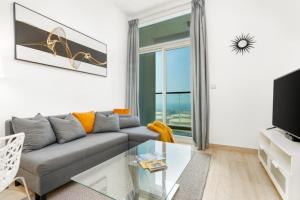 a living room with a couch and a glass table at GuestReady - Stunning Marina Apt close to the beach in Dubai