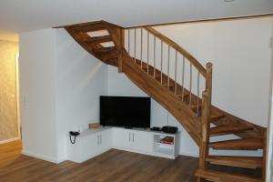 a living room with a staircase and a television at LA2 f - Ferienreihenhaus LA2 in Schottwarden