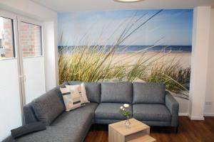 a living room with a couch and a painting of the beach at LA2 f - Ferienreihenhaus LA2 in Schottwarden