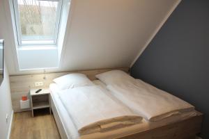 a small bed in a room with a window at LA2 f - Ferienreihenhaus LA2 in Schottwarden