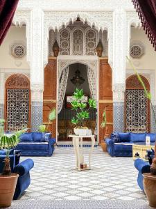 ein Wohnzimmer mit blauen Sofas und einem Tisch in der Unterkunft Le Riad Palais d'hotes Suites & Spa Fes in Fès