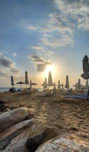 a group of chairs and umbrellas on a beach at Verde rete apartments2 in Áno Stavrós