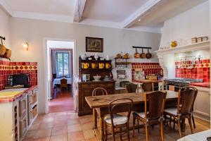 uma cozinha com uma mesa de madeira e cadeiras em l'ermitage em Sault-de-Vaucluse