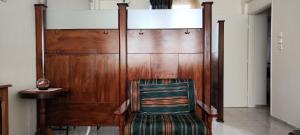 テッサロニキにあるEleni-apartmentsの木製の扉前に座る椅子