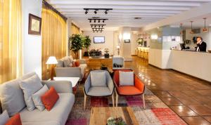 a living room with couches and chairs and a kitchen at Catalonia Conde de Floridablanca in Murcia