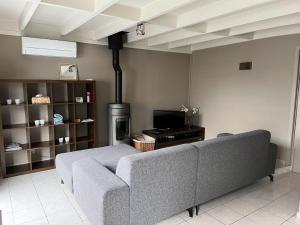 Una sala de estar con un sofá y una estufa. en Nieuwendamme 88, en Nieuwpoort