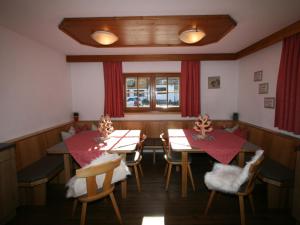 un comedor con 2 mesas y sillas y una ventana en Chalet Heisenhaushütte - MHO684 by Interhome, en Ramsau im Zillertal