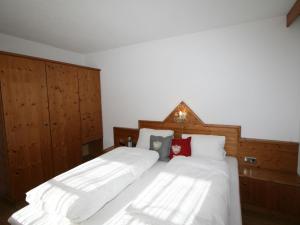 1 dormitorio con 2 camas con sábanas blancas y almohadas rojas en Chalet Heisenhaushütte - MHO684 by Interhome, en Ramsau im Zillertal