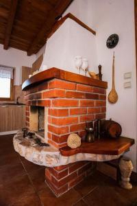 a kitchen with a brick fireplace in a room at Vikendica Kristina in Prijedor